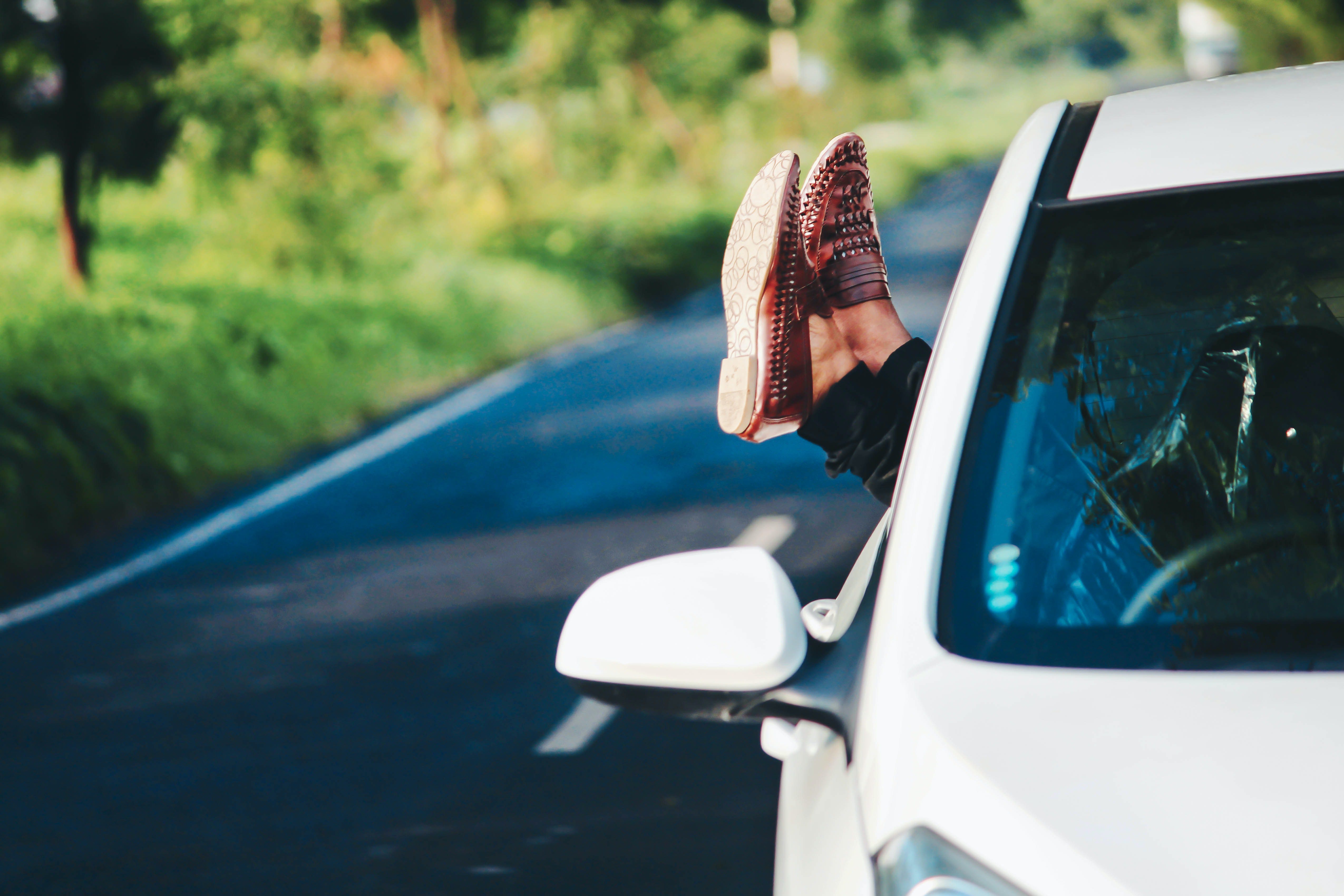 Feet out of the car window on the road